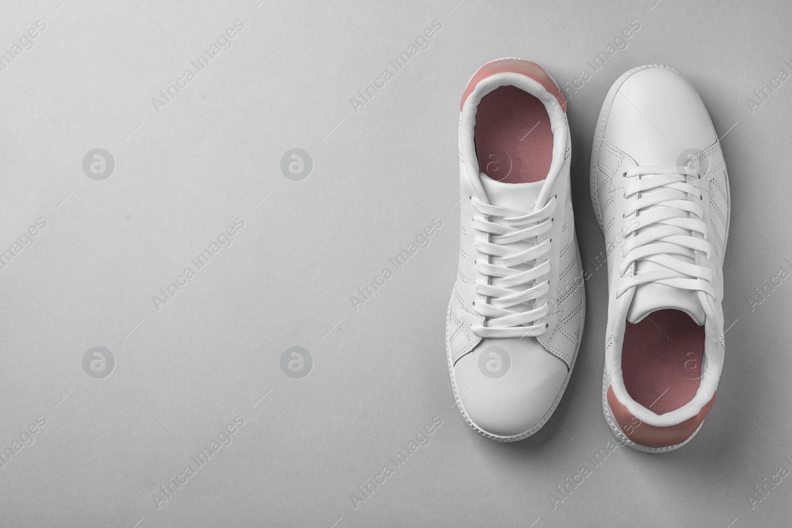 Photo of Pair of trendy sneakers on light background, flat lay. Space for text