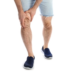 Photo of Young man suffering from leg pain on white background, closeup