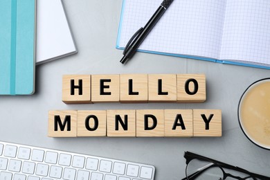 Photo of Wooden cubes with message Hello Monday and office stationery on light desk, flat lay