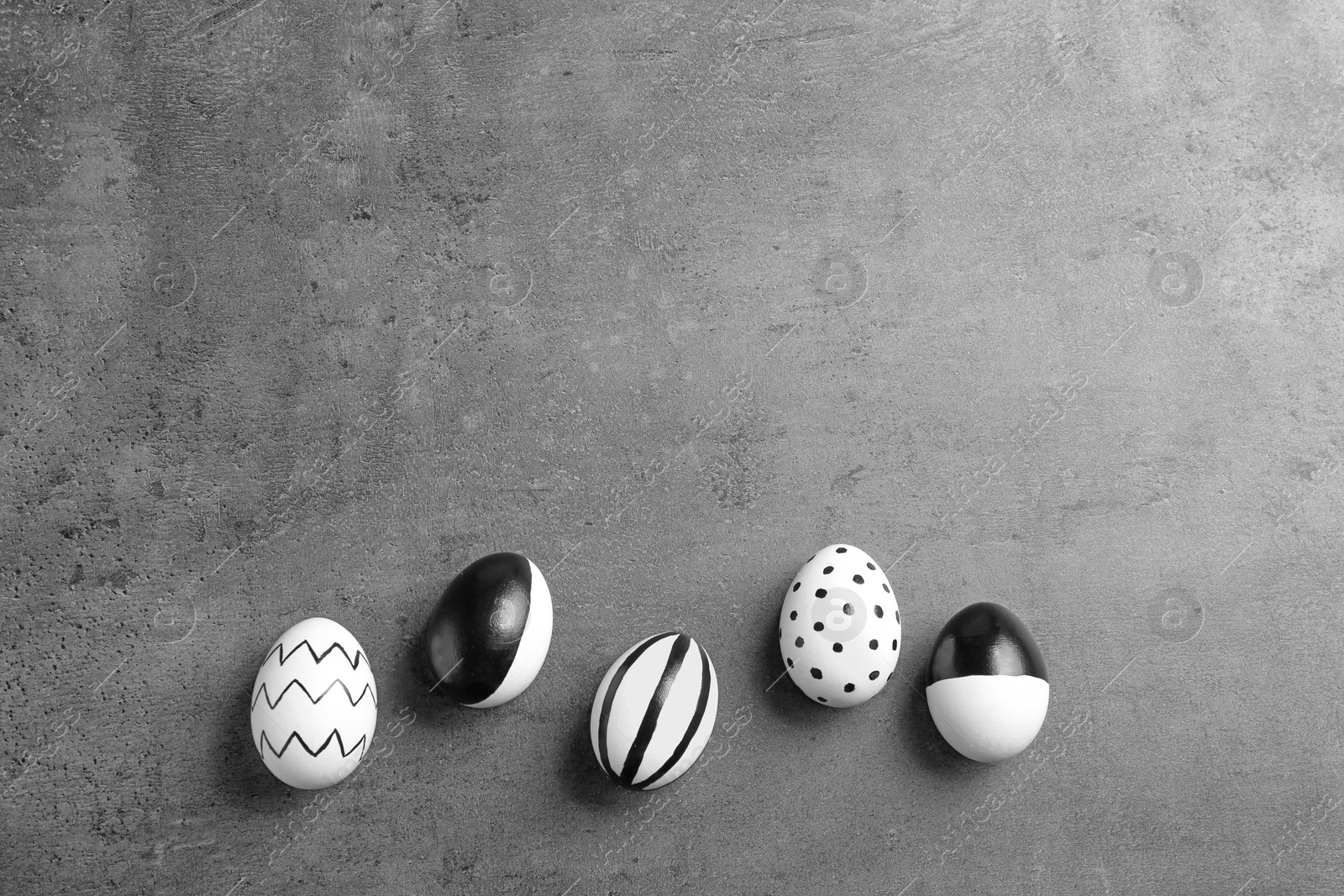 Photo of Painted Easter eggs on grey background, flat lay with space for text