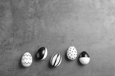 Photo of Painted Easter eggs on grey background, flat lay with space for text