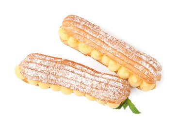 Photo of Delicious eclairs filled with cream and mint isolated on white, top view