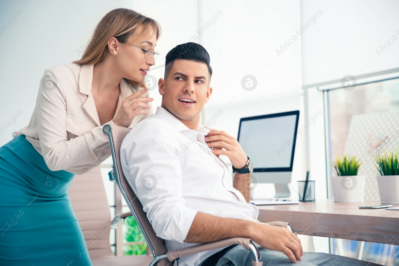 Photo of Young woman flirting with her colleague during work in office