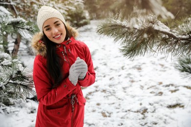 Photo of Happy young woman outdoors on winter day. Space for text