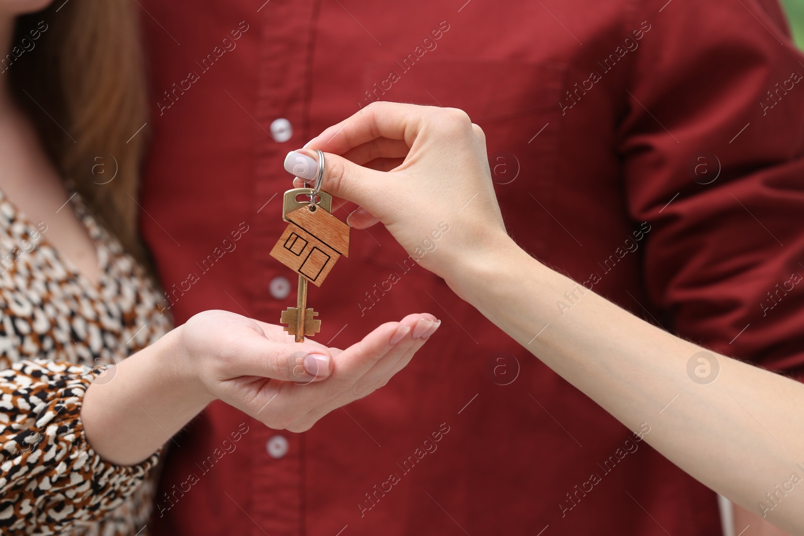 Photo of Real estate agent giving house key to couple, closeup