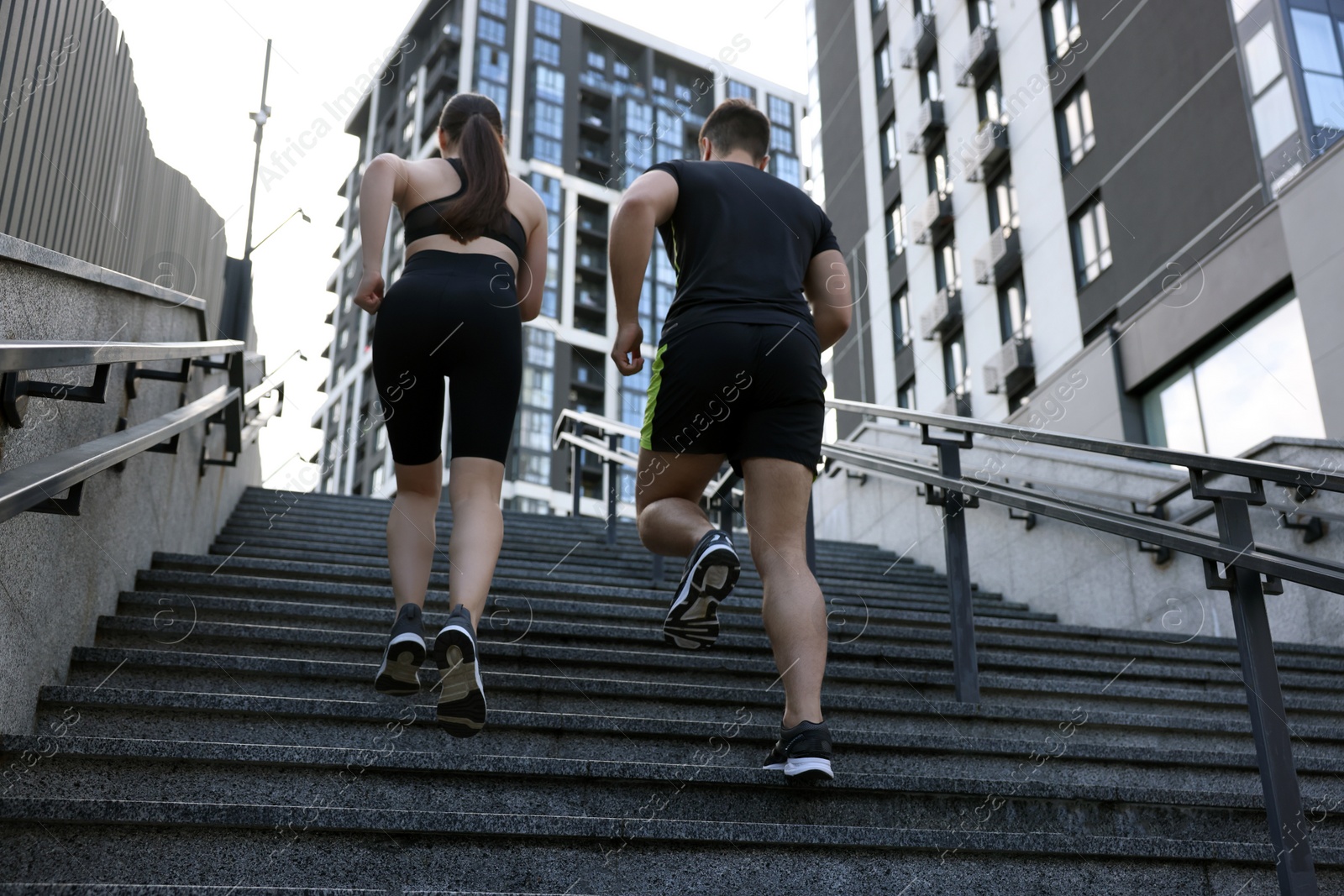 Photo of Healthy lifestyle. Couple running up steps outdoors, low angle view