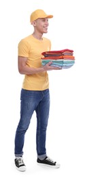 Photo of Dry-cleaning delivery. Happy courier holding folded clothes on white background