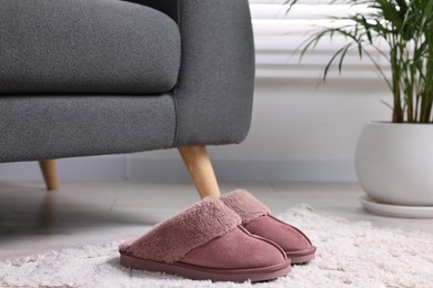 Photo of Pink soft slippers on light carpet indoors