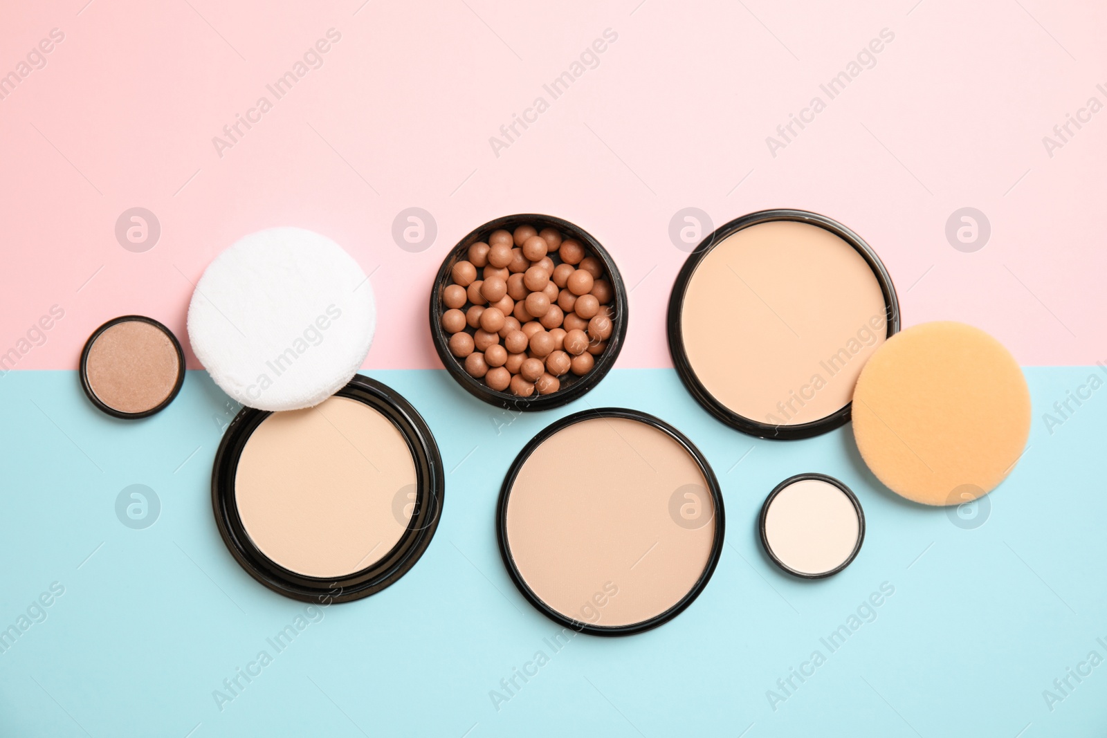 Photo of Flat lay composition with various makeup face powders on color background