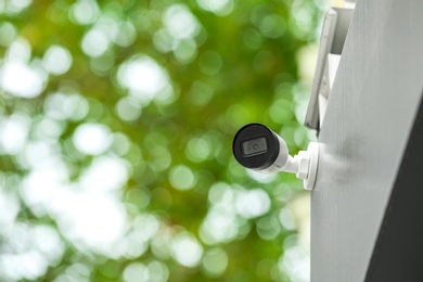 Photo of Modern CCTV security camera on building outdoors. Space for text