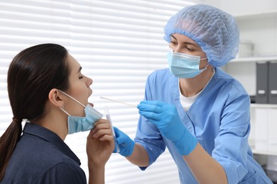 Photo of Laboratory testing. Doctor taking sample from patient's mouth with cotton swab in hospital