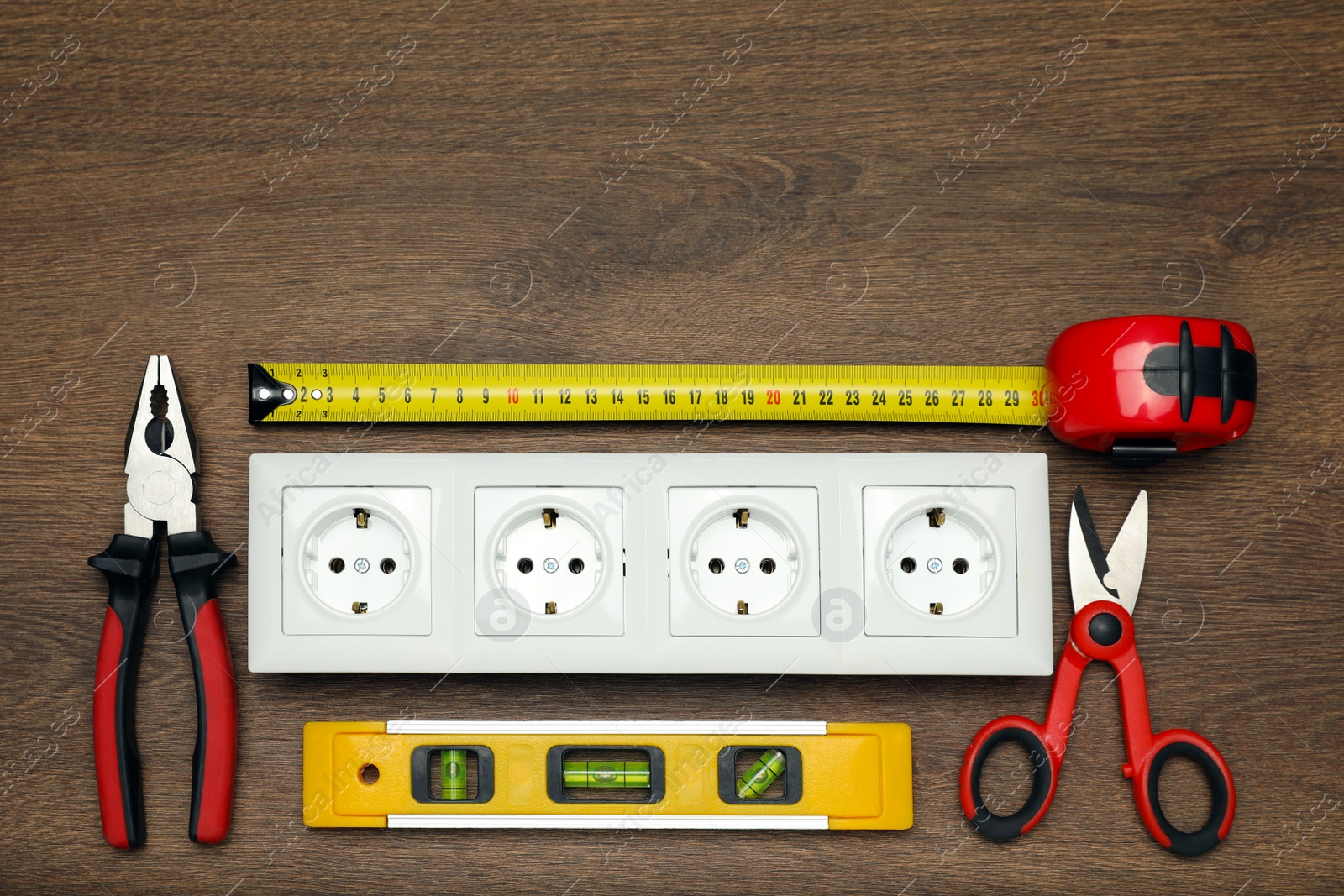 Photo of Power socket and set of electrician's tools on wooden table, flat lay. Space for text