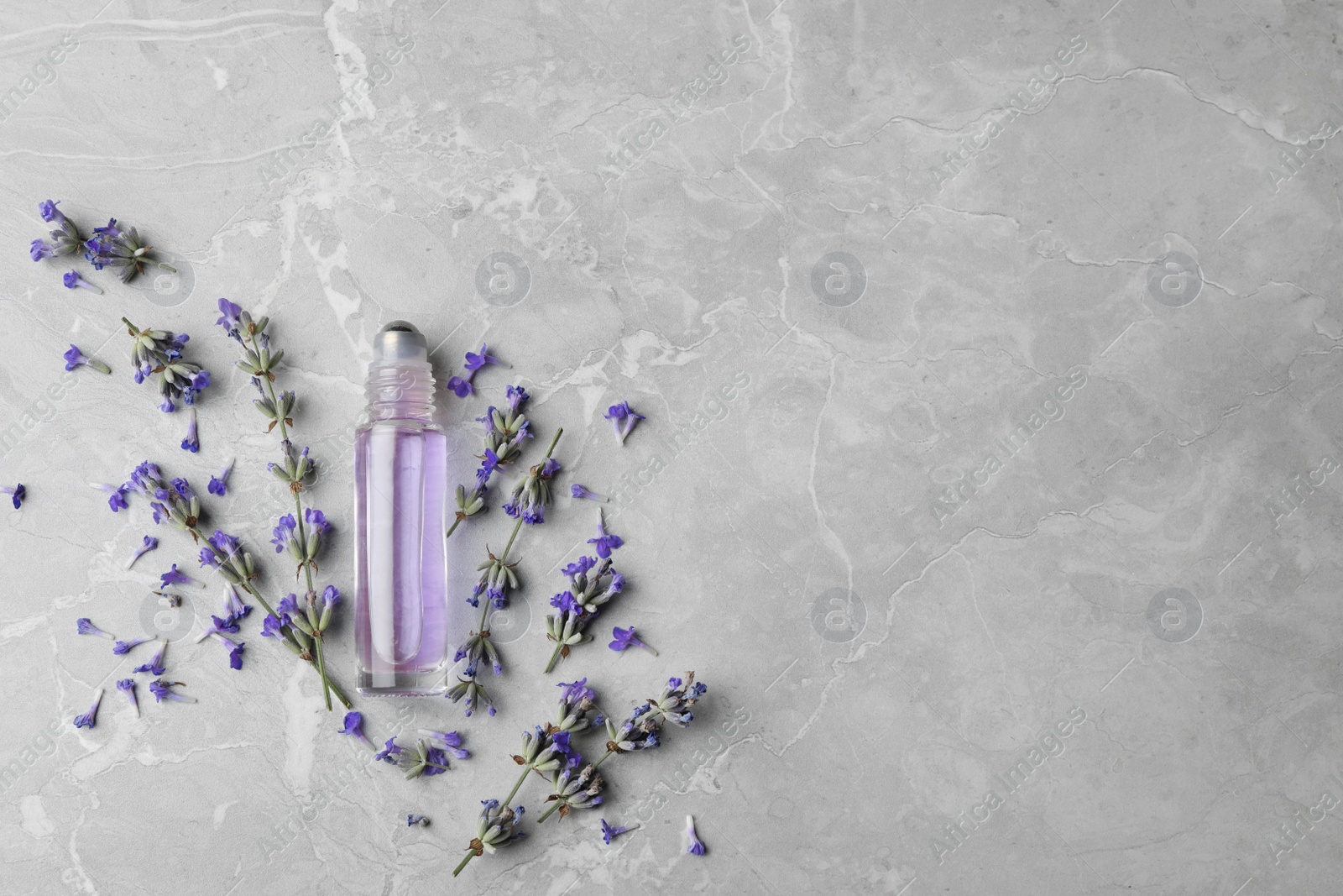 Photo of Flat lay composition with natural lavender essential oil on marble table, space for text