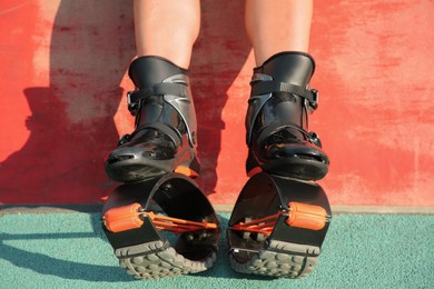 Photo of Woman with kangoo jumping boots outdoors, closeup