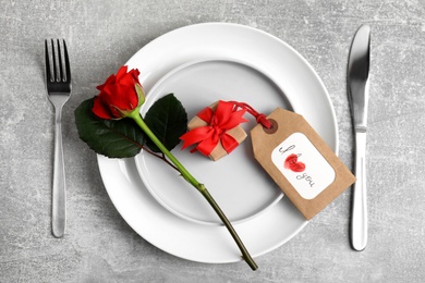 Photo of Beautiful table setting for romantic dinner on light grey background, flat lay. Valentine's day celebration