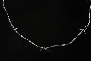 Photo of Shiny metal barbed wire on black background