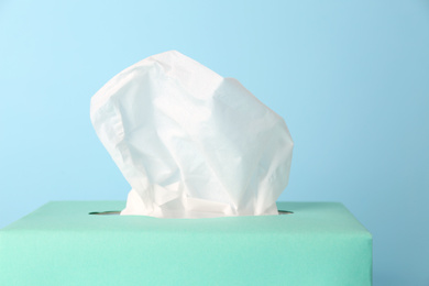 Photo of Box of paper tissues on light blue background, closeup