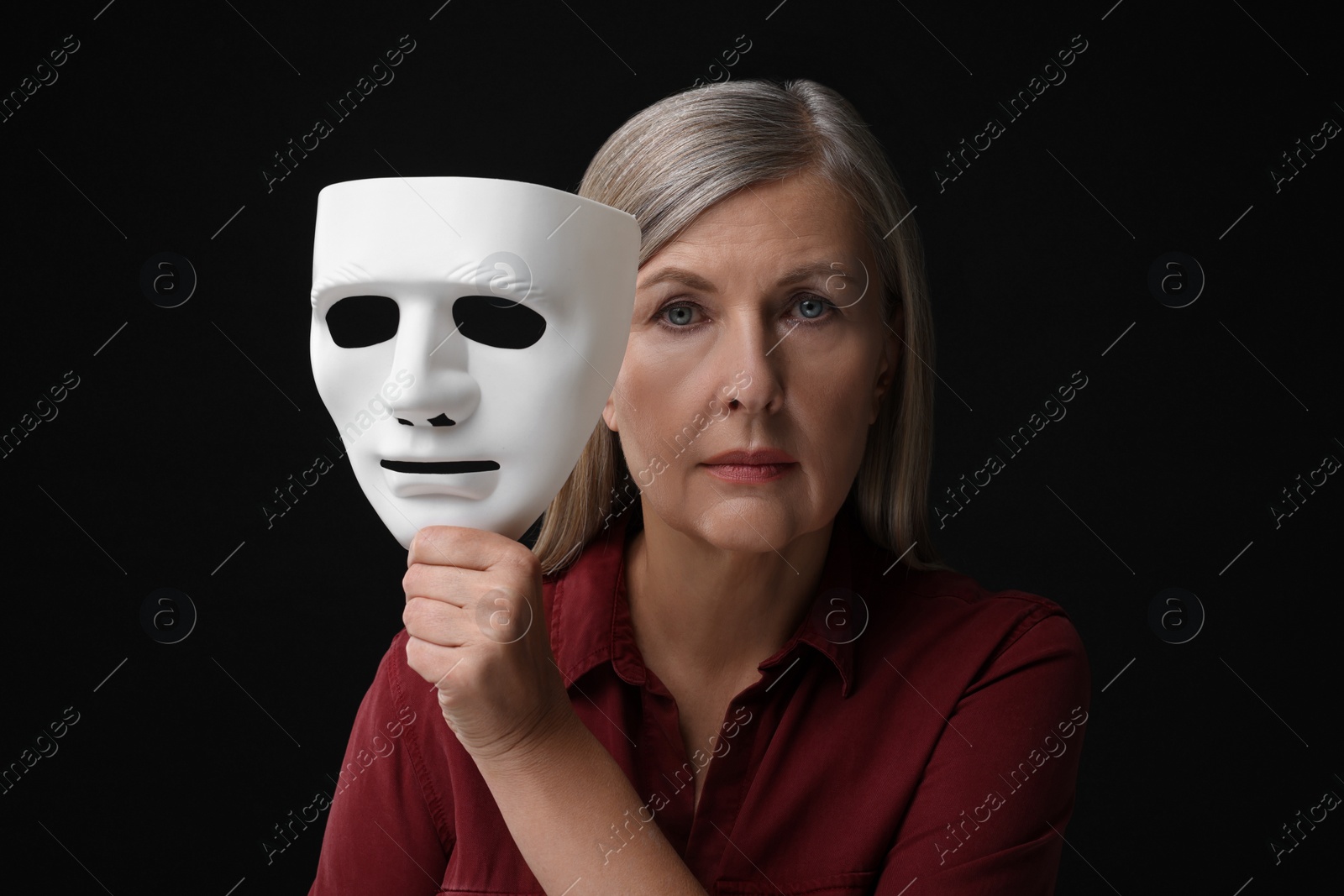 Photo of Multiple personality concept. Woman with mask on black background