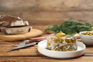 Photo of Delicious aspic with meat on wooden table, space for text