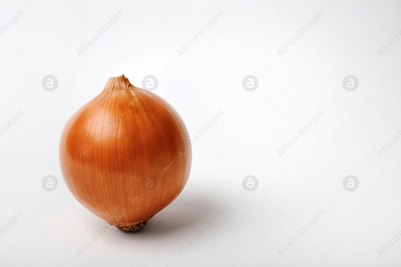 Photo of Fresh ripe onion bulb on light background