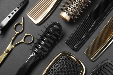 Photo of Hairdressing tools on dark background, flat lay