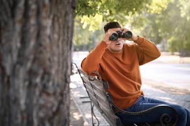Photo of Jealous man with binoculars spying on ex girlfriend in park