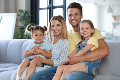 Photo of Happy family with little children on sofa in living room