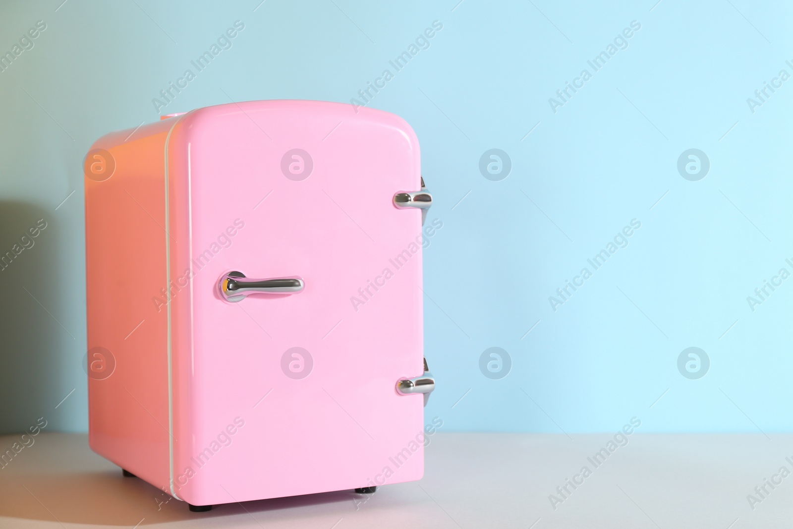 Photo of Cosmetic refrigerator on color background, space for text