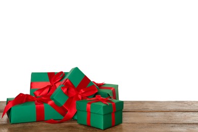 Beautifully wrapped gift boxes on wooden table against white background, space for text