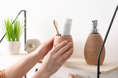 Bath accessories. Woman organizing personal care products indoors, closeup