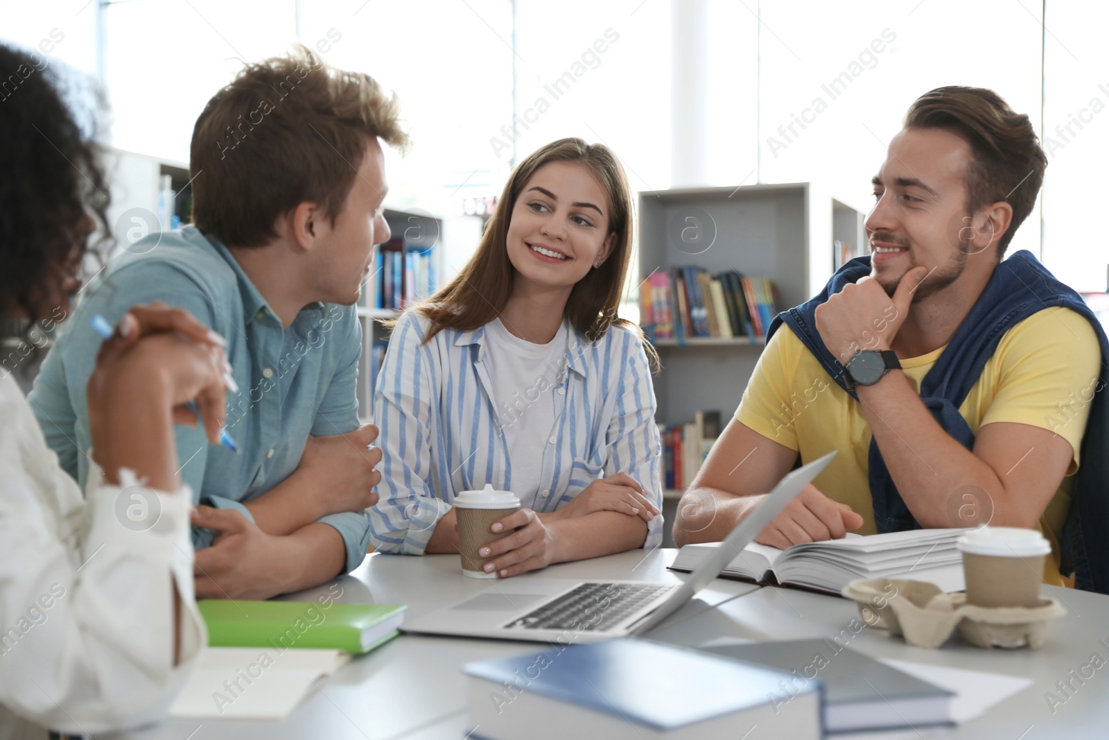 Photo of Group of young people studying at table in library