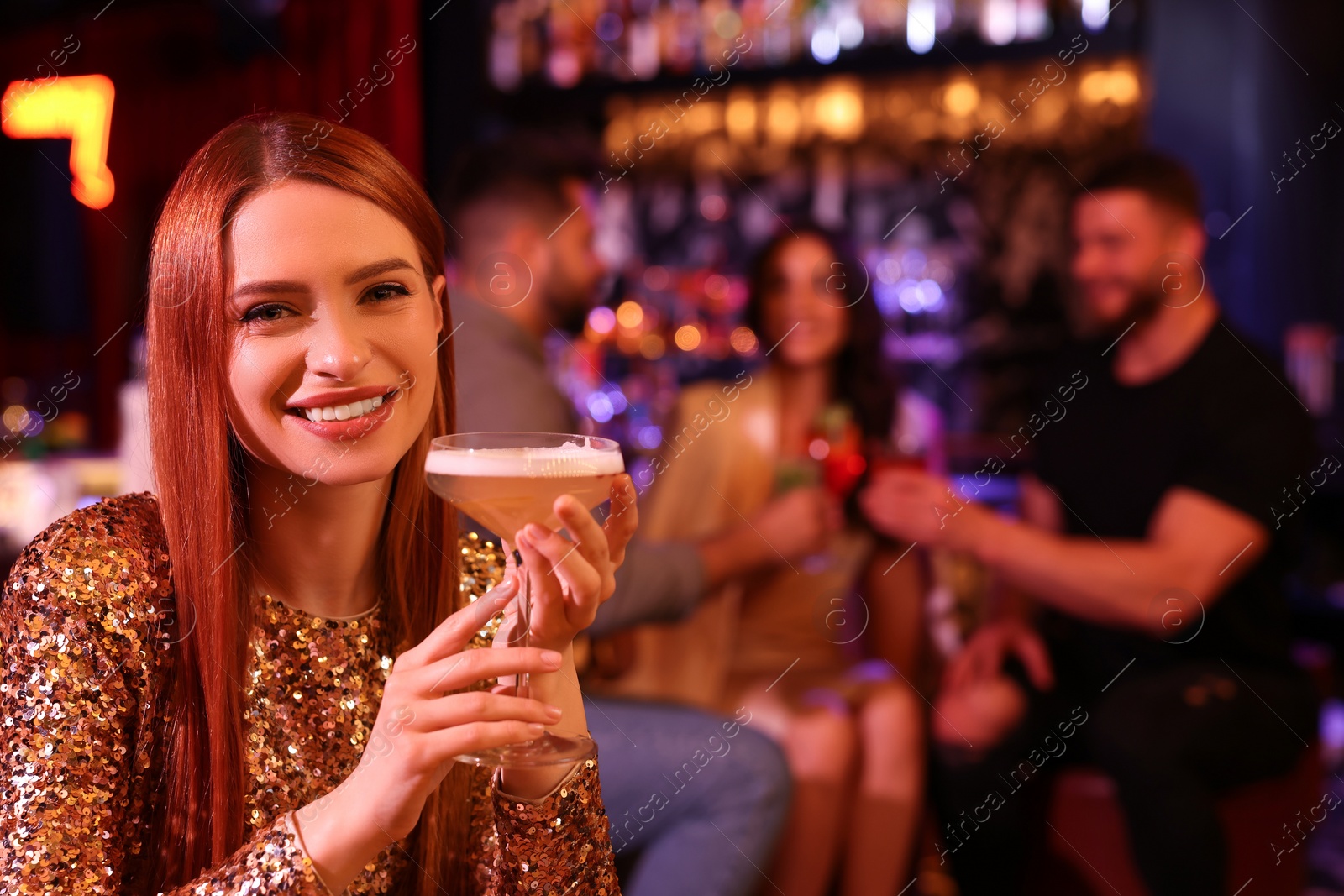 Photo of Friends spending time together in bar. Beautiful woman with fresh alcoholic cocktail, space for text