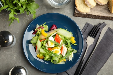 Photo of Delicious salad with crab sticks and lettuce on grey table, flat lay