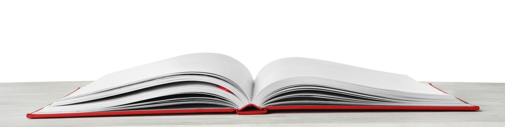 Photo of Open book with red cover on wooden table against white background