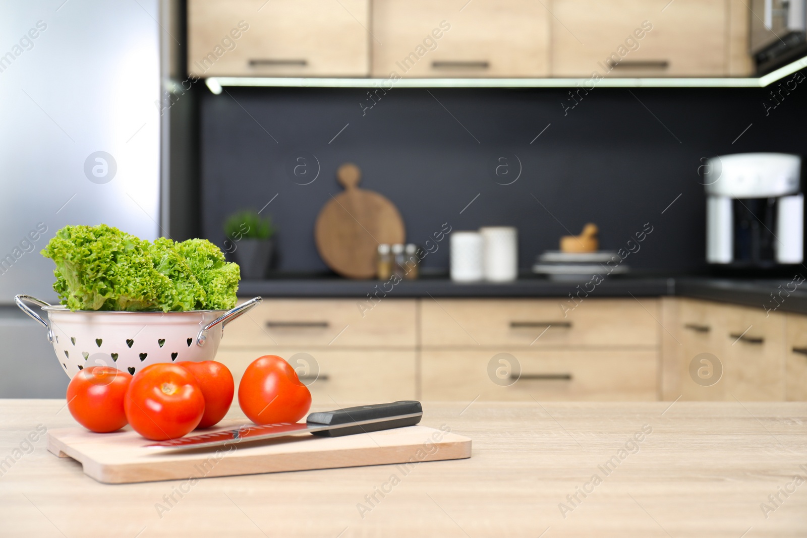 Photo of Fresh vegetables on wooden table in kitchen. Space for text