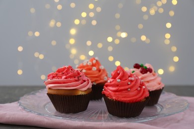 Photo of Delicious cupcakes with pink cream on grey table