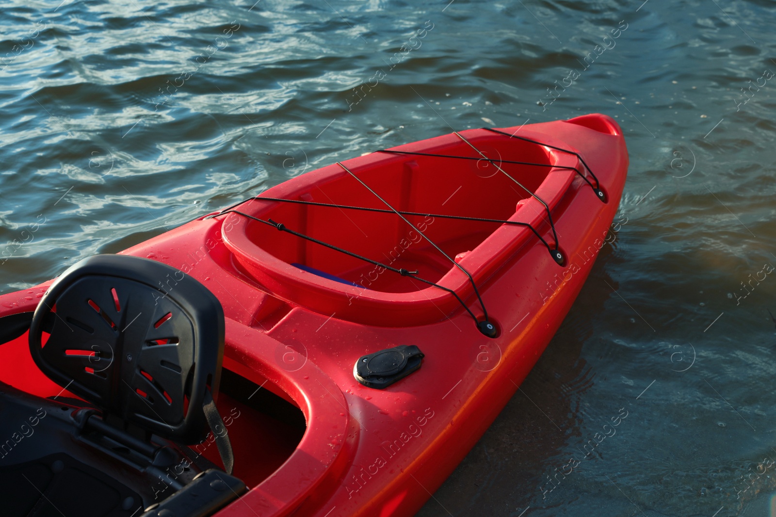 Photo of Beautiful modern red kayak on river, closeup
