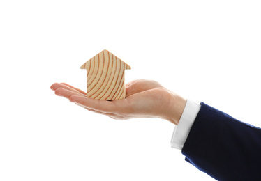 Photo of Real estate agent holding house figure on white background, closeup