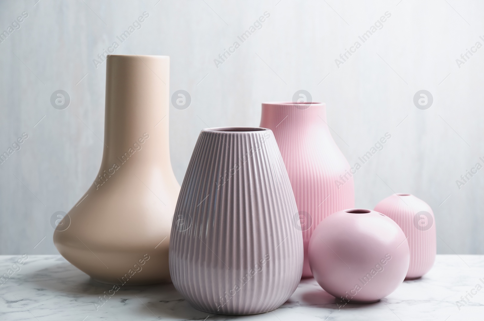 Photo of Stylish empty ceramic vases on white marble table