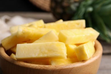 Pieces of tasty ripe pineapple in bowl on table, closeup