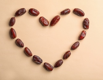 Photo of Frame made of sweet dried date fruits on color background, top view with space for text