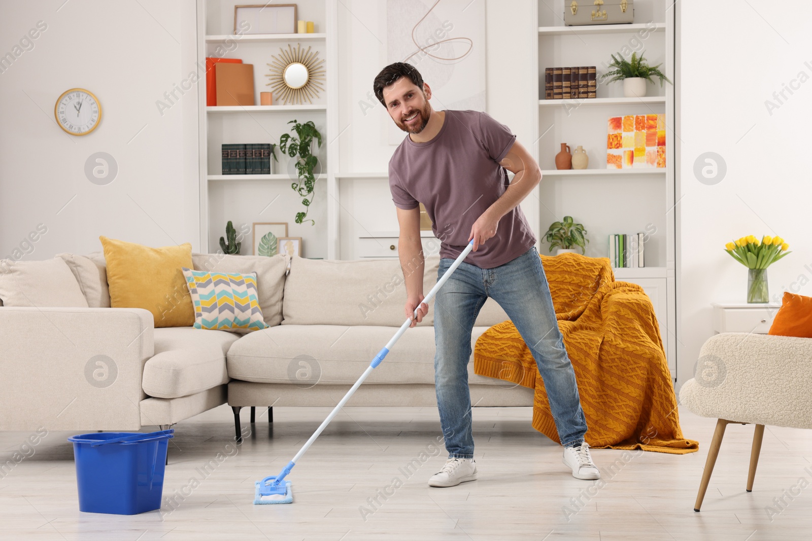 Photo of Spring cleaning. Man with mop washing floor at home