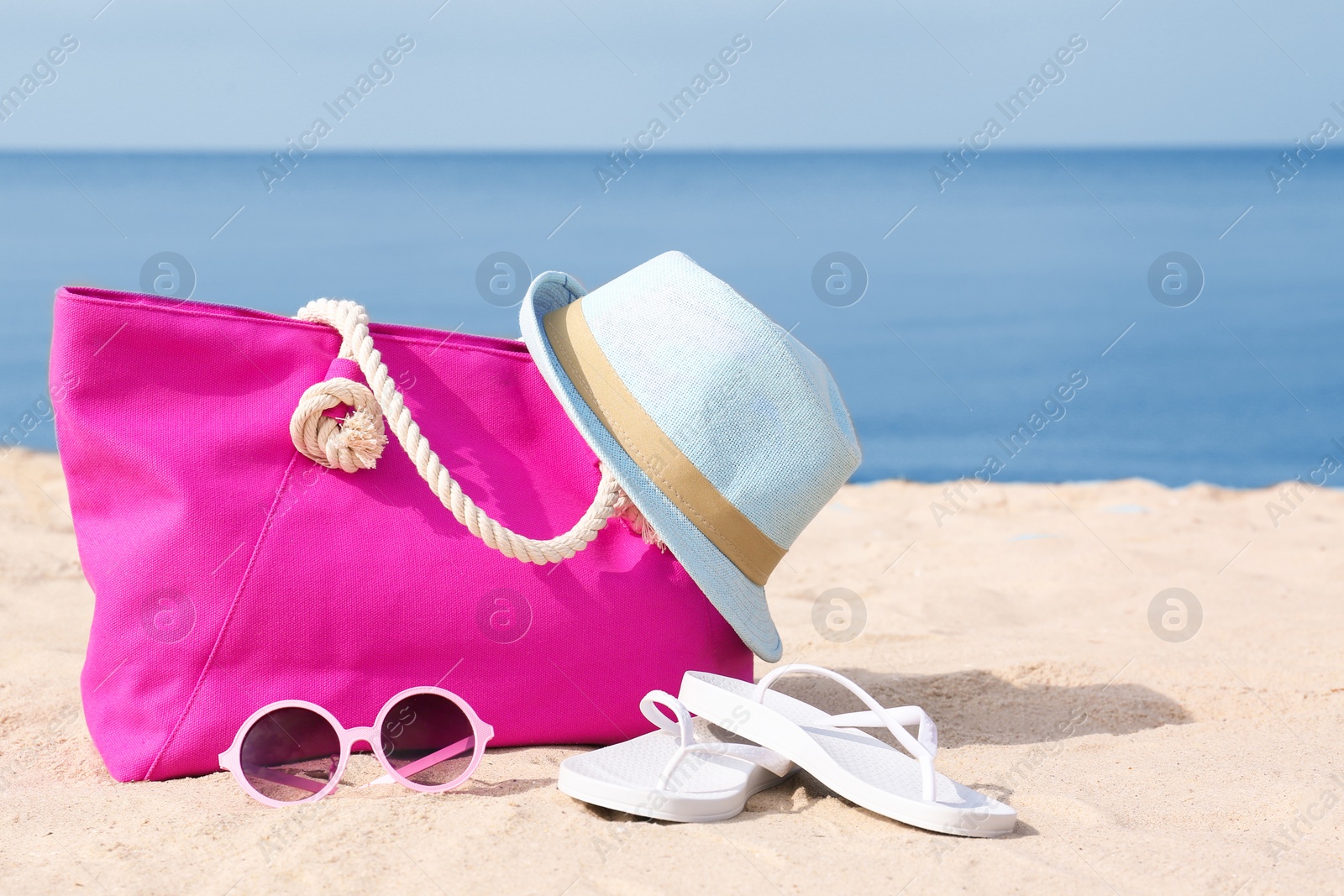 Photo of Set of different stylish beach accessories on sand. Space for text