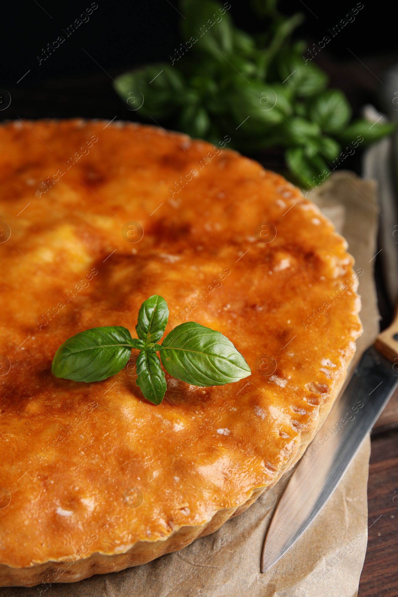 Photo of Delicious pie with meat and basil on wooden table