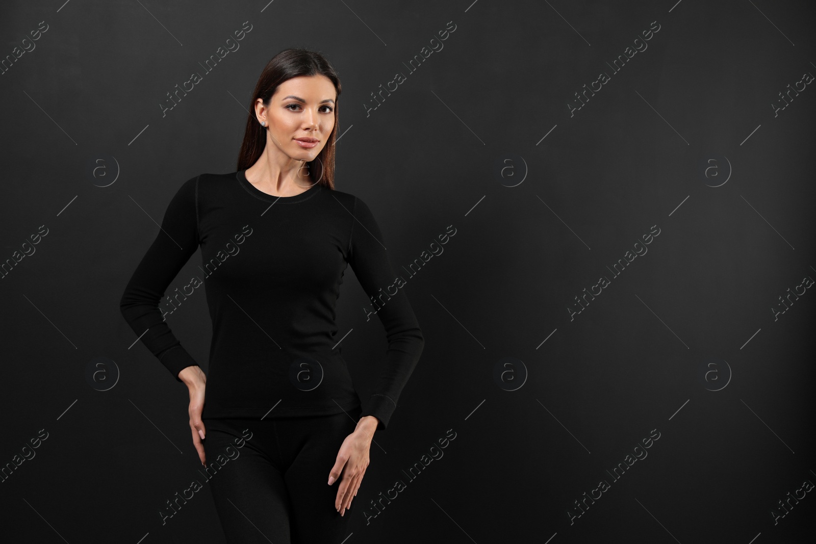 Photo of Woman wearing thermal underwear on black background. Space for text