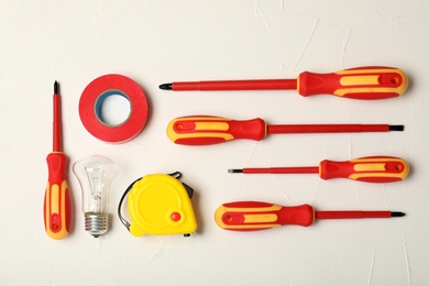 Flat lay composition with electrician's tools on light background