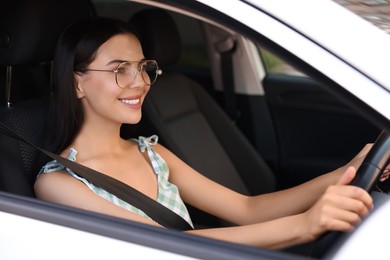Photo of Enjoying trip. Happy young woman driving her car, view from outside