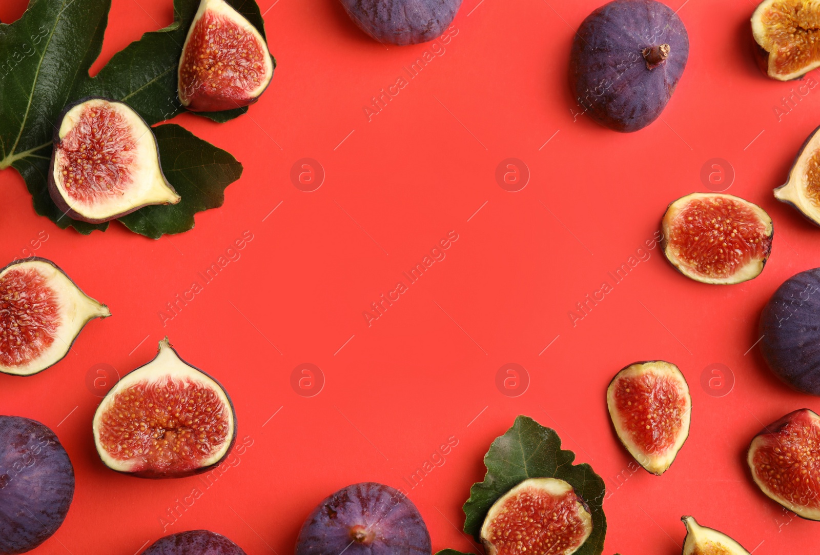 Photo of Delicious ripe figs and green leaves on red background, flat lay. Space for text