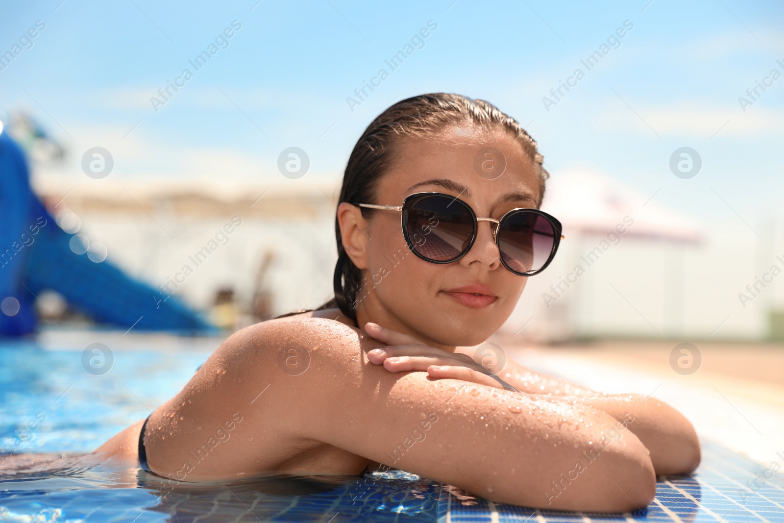 Photo of Young woman in outdoor swimming pool. Summer vacation