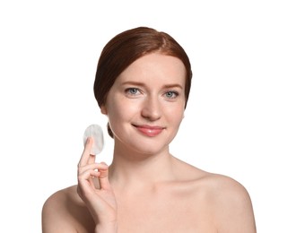 Photo of Beautiful woman with freckles holding cotton pad on white background